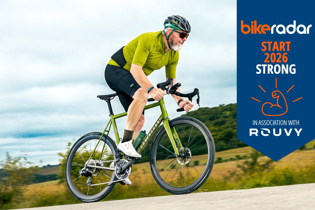 Warren wearing green on road bike with Rouvy banner