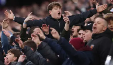 West Ham fans raise their arms and sing to back the team