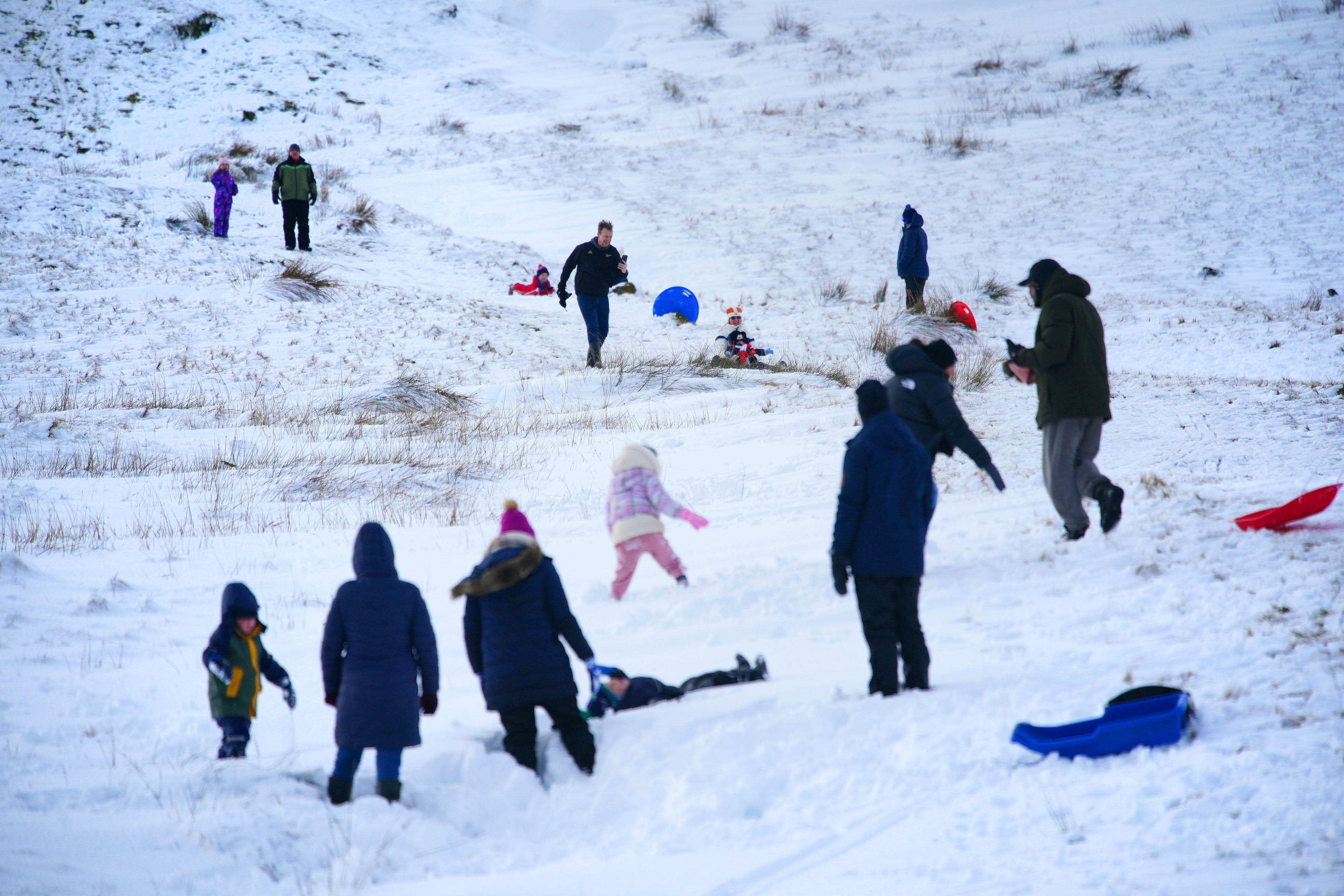 People sledging and playing in the snow in the Bannau Brycheiniog National Park