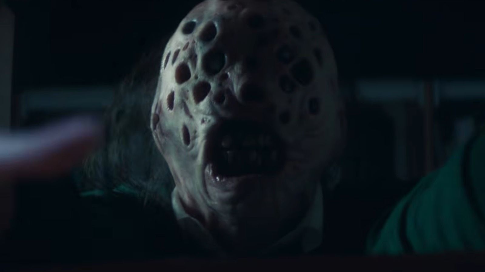 Monster man with multiple holes in his head grabbing at camera in Blood Covenant