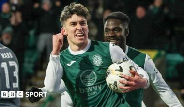 Hibs striker Kieron Bowie celebrates as he clenches his right fist and carries the ball in his left hand