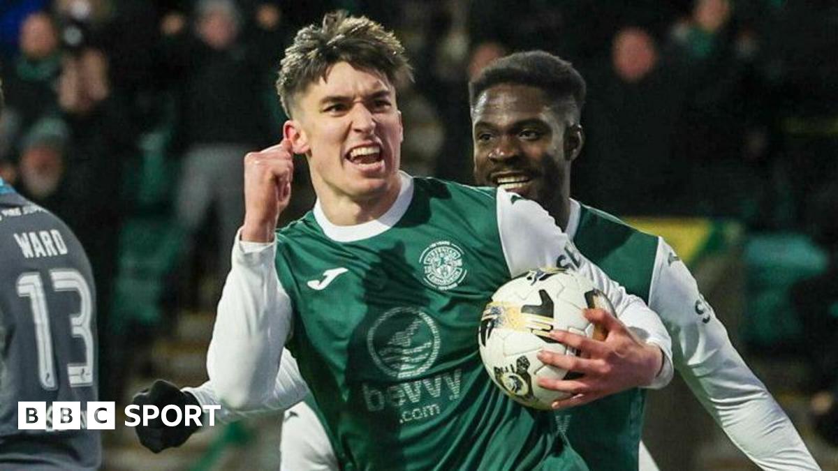 Hibs striker Kieron Bowie celebrates as he clenches his right fist and carries the ball in his left hand