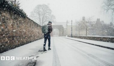 Man walks along a snow covered street with a rucksack on his back