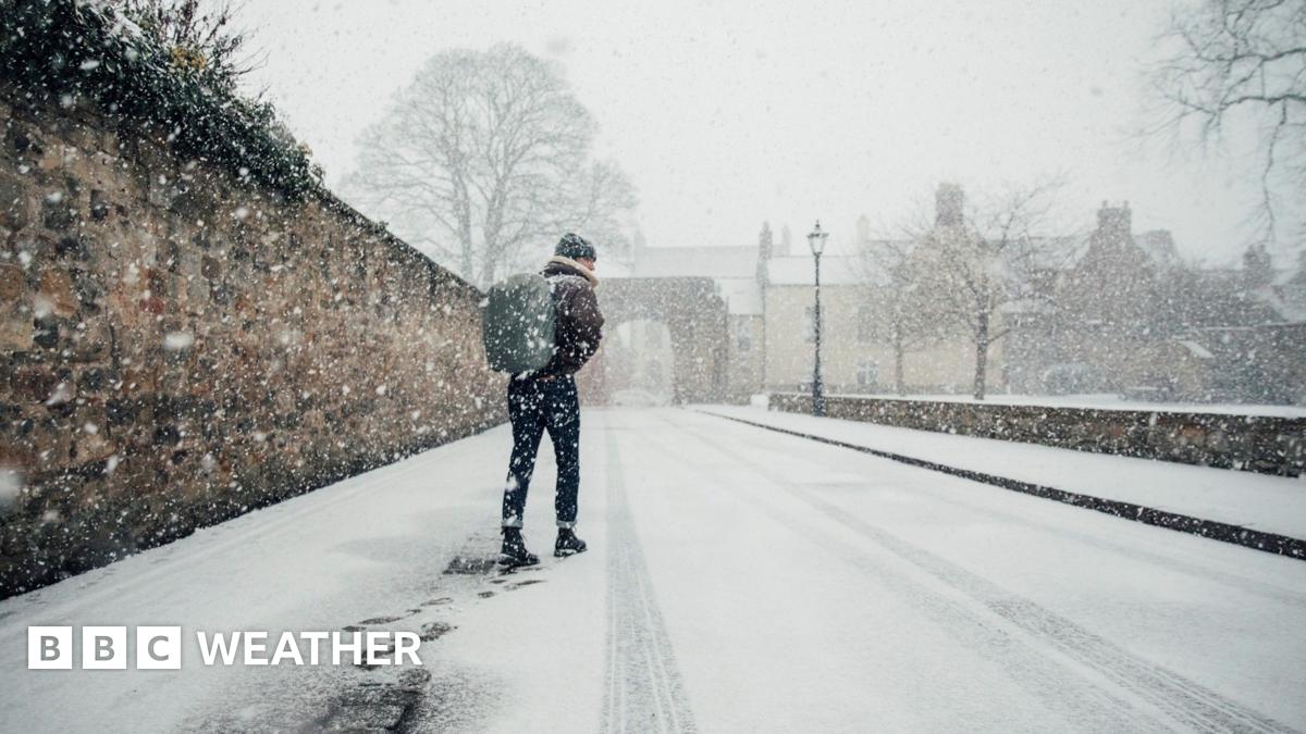 Man walks along a snow covered street with a rucksack on his back