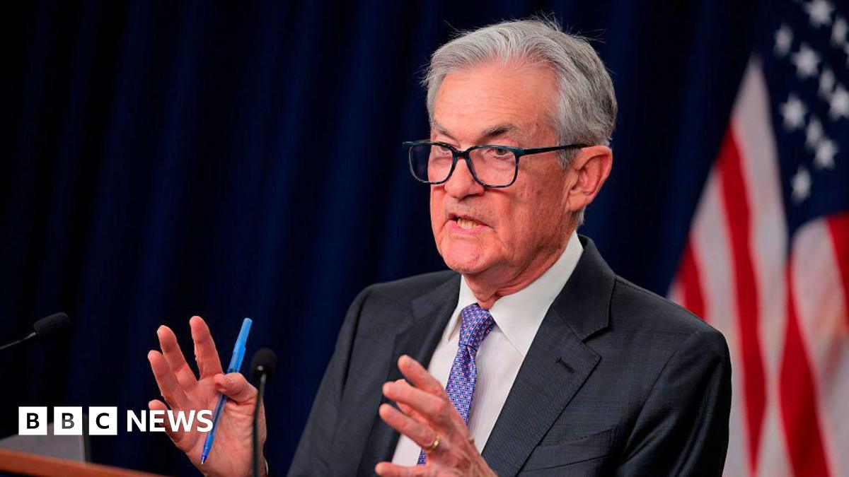 Jerome Powell seen speaking at a podium. He is motioning with his hands