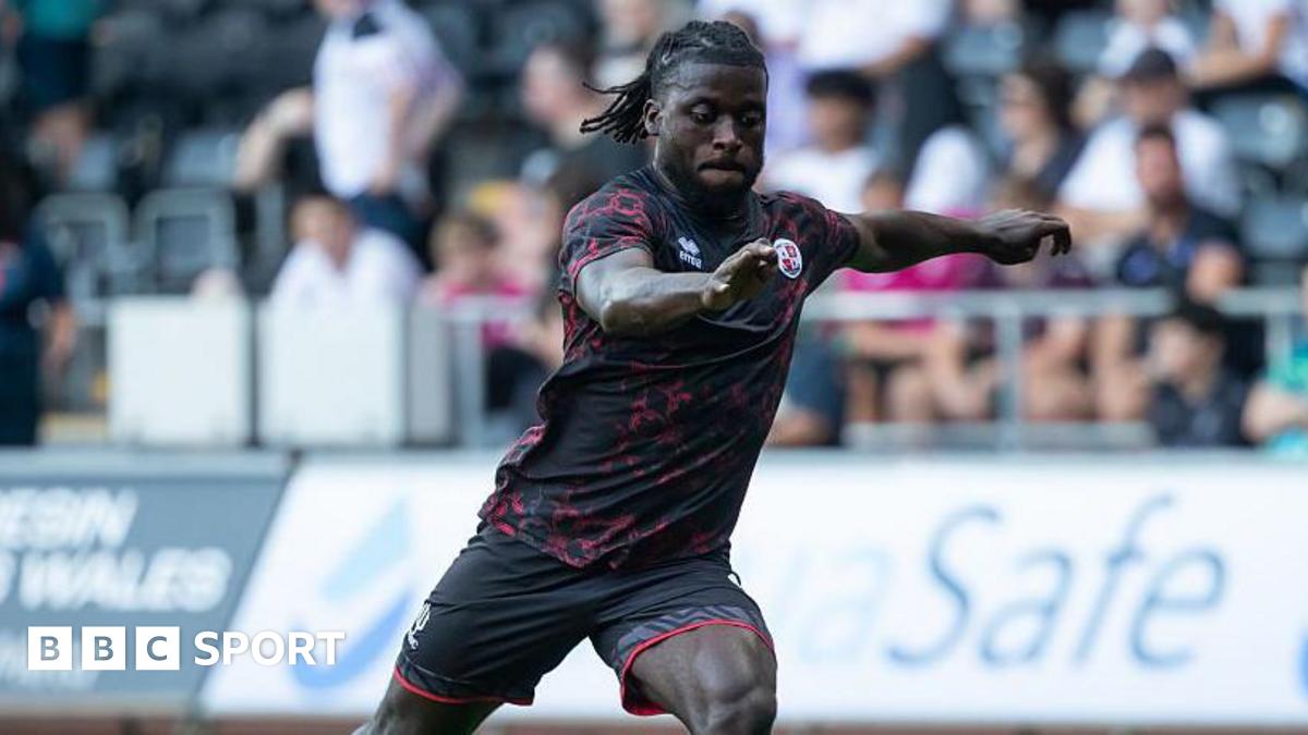 Kabongo Tshimanga running with one arm out and the ball at his feet during a pre-season match for Crawley in August 2025