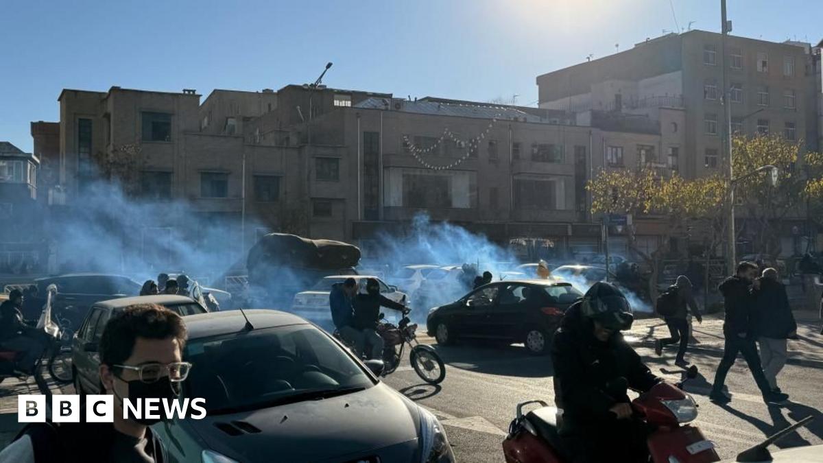 A street-view image of Iranian shopkeepers and traders protesting on motorbikes and on foot in between cars with tear gas is visible.