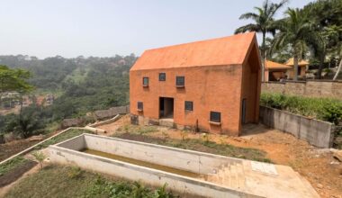 clay monolithic villas emerge from ghana’s red earth landscape
