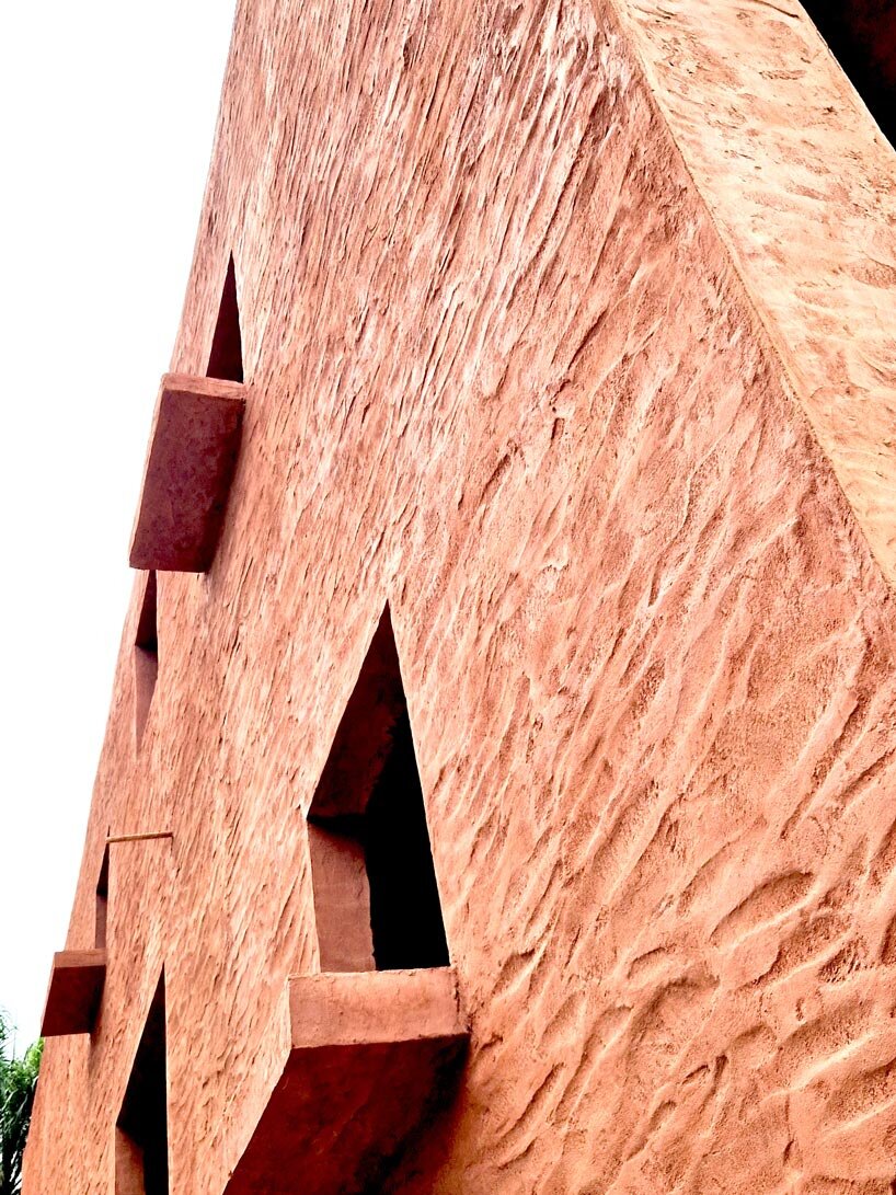 clay monolithic villas emerge from ghana’s red earth landscape
