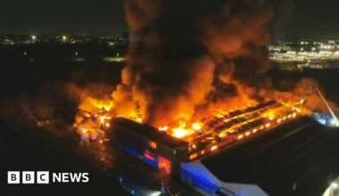 An aerial image of a large building on fire with glowing orange flames