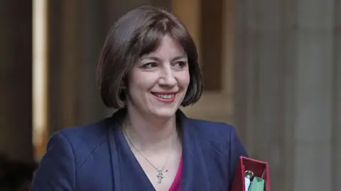 PA Media A head and shoulders shot shows Bridget Phillipson wearing a navy coat, carrying a red folder with documents inside, as she arrives for a recent Cabinet meeting in Downing Street.