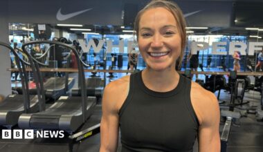 Picture of a woman smiling in front of gym equipment