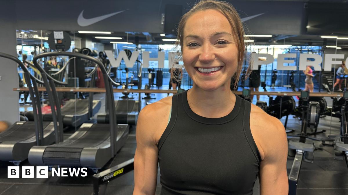 Picture of a woman smiling in front of gym equipment