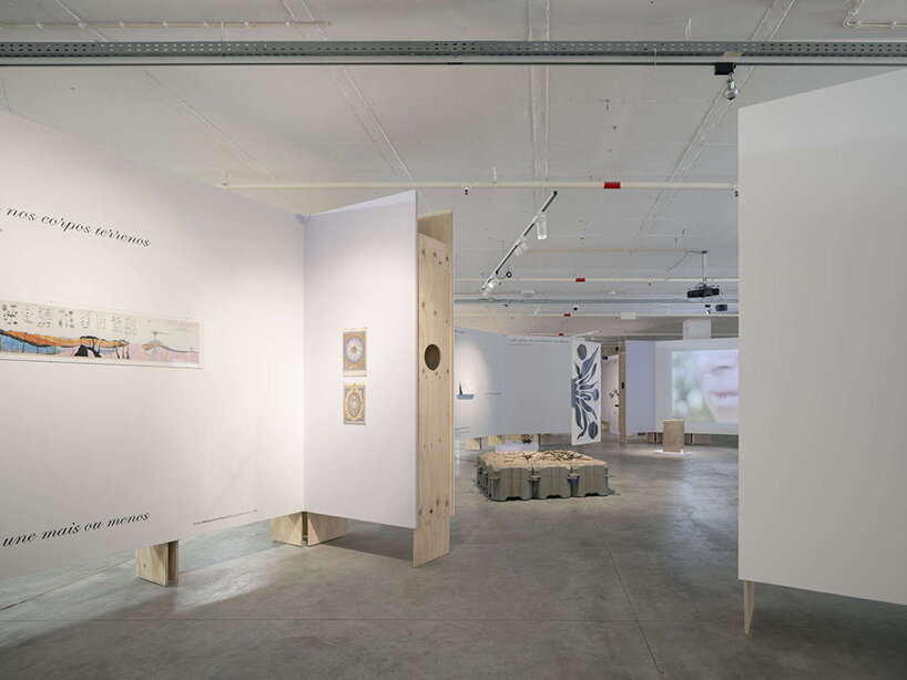 angled partitions organize exhibition content while maintaining visual continuity across the open plan