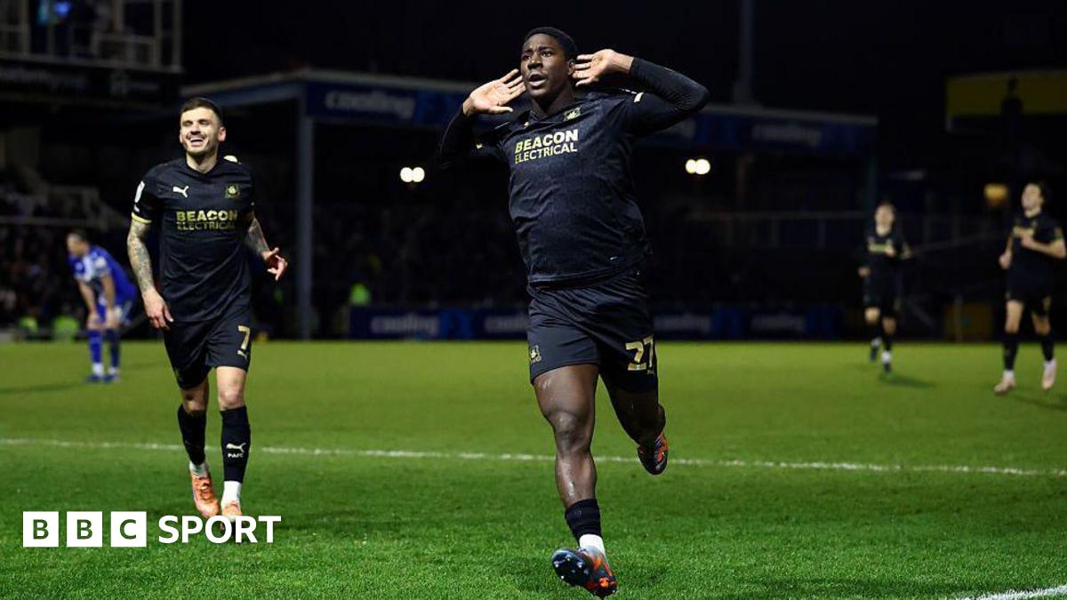 Plymouth Argyle's Aribim Pepple cups his hands to his ears as he runs to the fans to celebrate his match-winning goal.