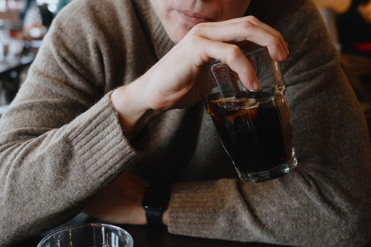 Close-up of mid adult man sipping drink at restaurant