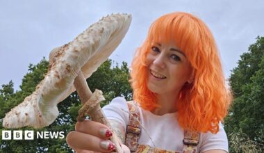 Mrs Gather with bright orange hair holding a large white mushroom