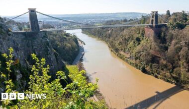 The Clifton Suspension Bridge seen from above over the River Avon. Bristol can be seen in the distance.