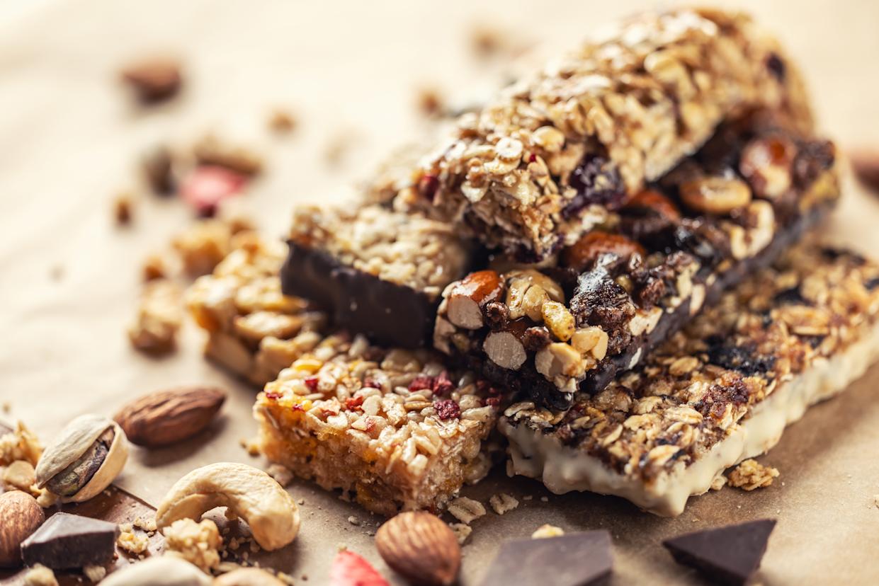 Various granola bars on baking paper. Cereal granola bars wit raspberries. Superfood breakfast bars with oats, nuts and berries, close up. Superfood concept