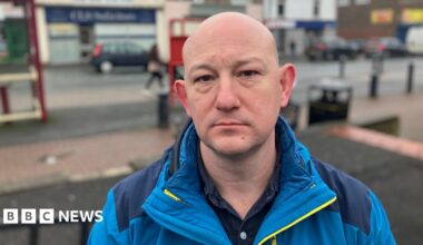 A man in a bright blue jacket stands in Featherstone