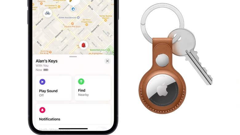 An Apple AirTag on a key next to a phone running the Find My app.