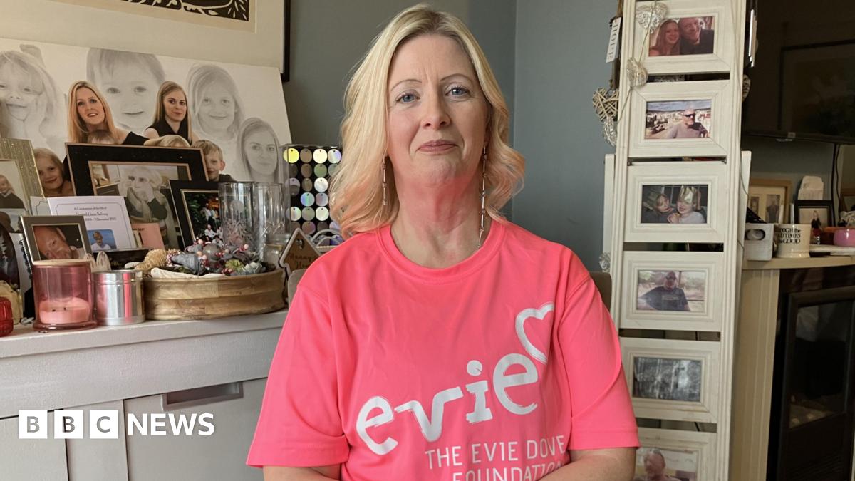 Prime Minister Mark Carney, wearing a black suit jacket, and a white button-up shirt leans his chin on his hands. He has short grey and black hair and is looking away from the camera.