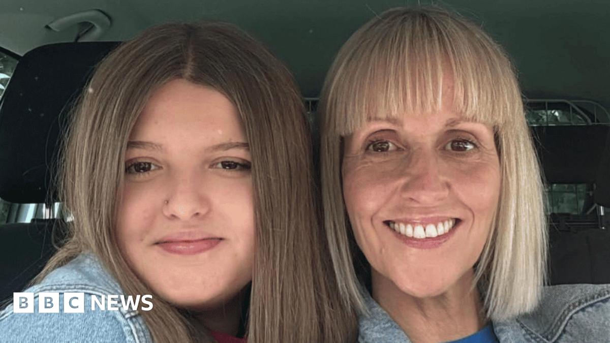 A mother and daughter pose for a selfie inside a car
