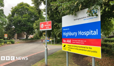 Prime Minister Mark Carney, wearing a black suit jacket, and a white button-up shirt leans his chin on his hands. He has short grey and black hair and is looking away from the camera.