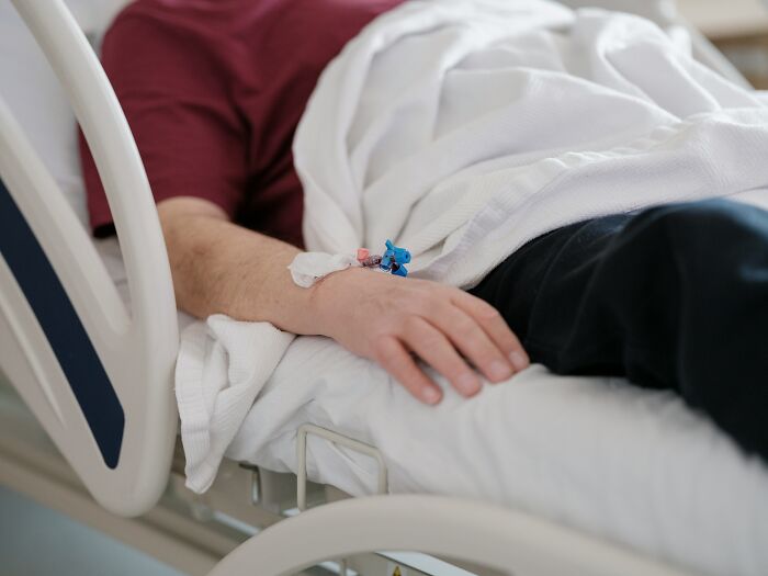 Patient lying in hospital bed with IV drip, illustrating stories of patients leaving the hospital against medical advice.