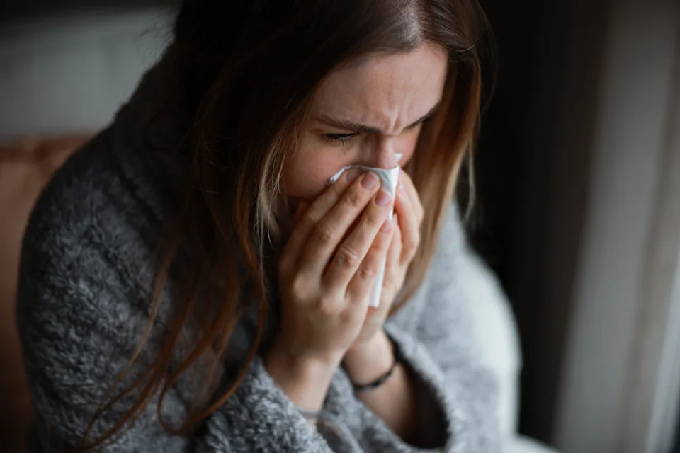 Close up young woman using hand for touching neck with feeling sore throat after wake up in the morning at bedroom , health care lifestyle people concept