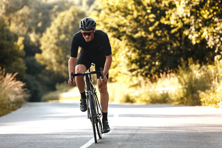 A man riding a bike along a road.