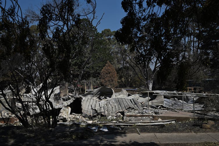 A crumpled mass of burnt corrogated iron on the ground, the former Ruffy Community Centre.