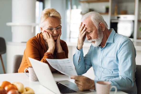 Frustrated mature couple having problems with paying their bills over Internet
