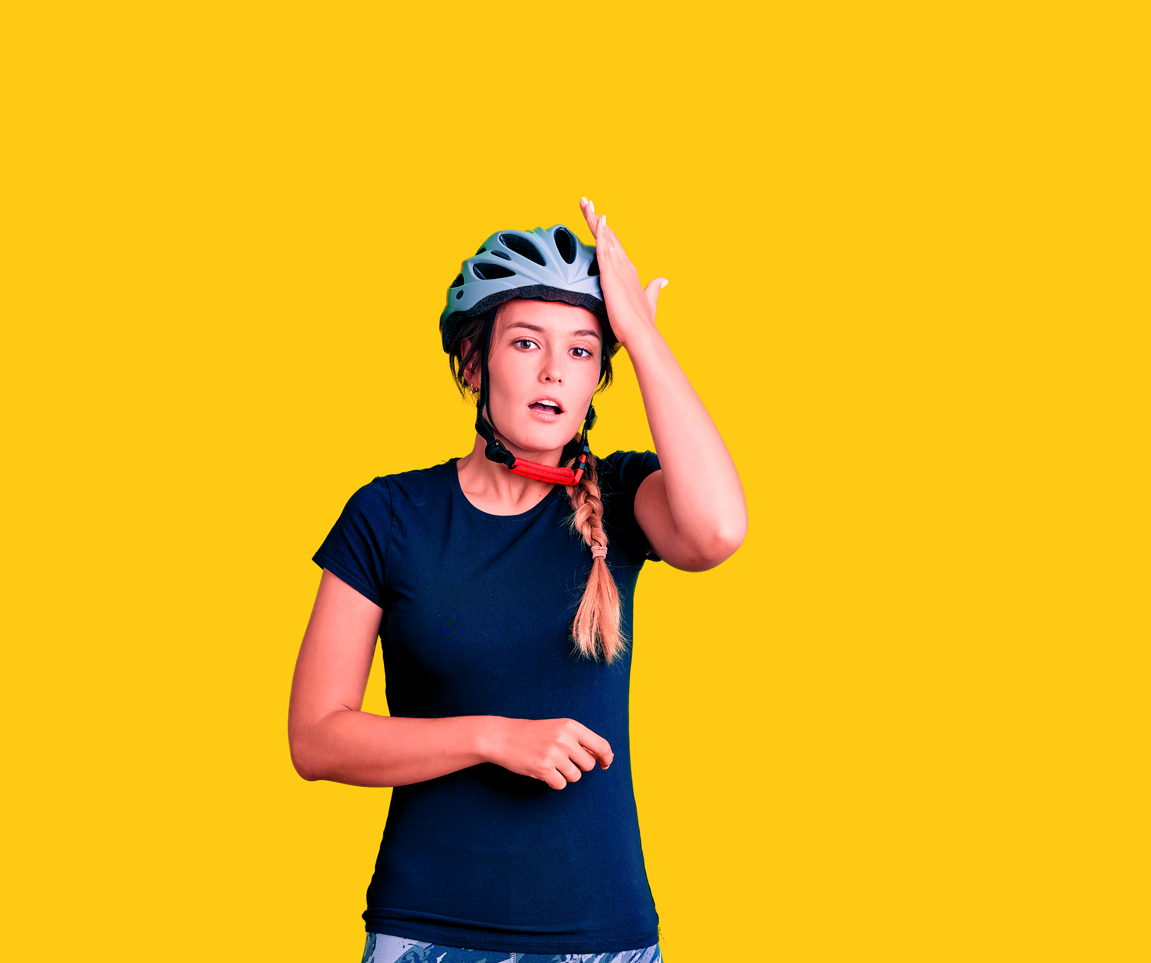 A woman in a helmet smacks her head to suggest forgetfulness