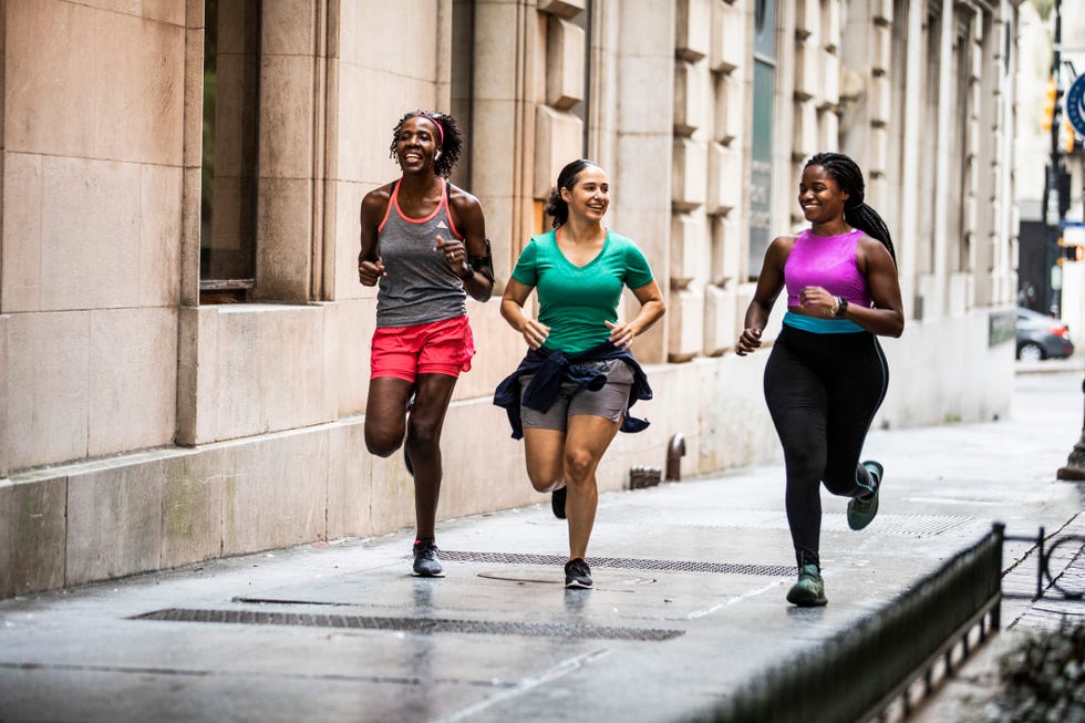 running and biological age: women running down an urban street.