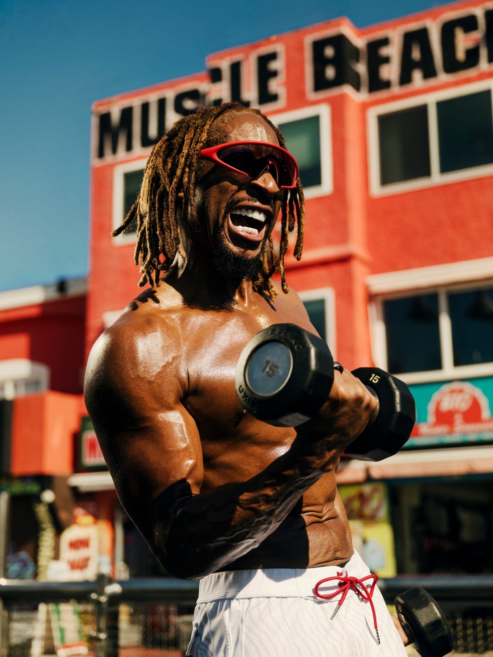a muscular individual exercising with dumbbells in an outdoor gym