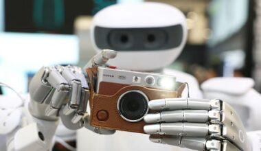 The Sharpa robot holds a Fujifilm instax camera and takes a photo, with the camera flash illuminated, at CES 2026.