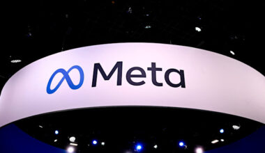 The Meta logo is displayed on a large white sign at a technology fair, with blue stage lights visible below.