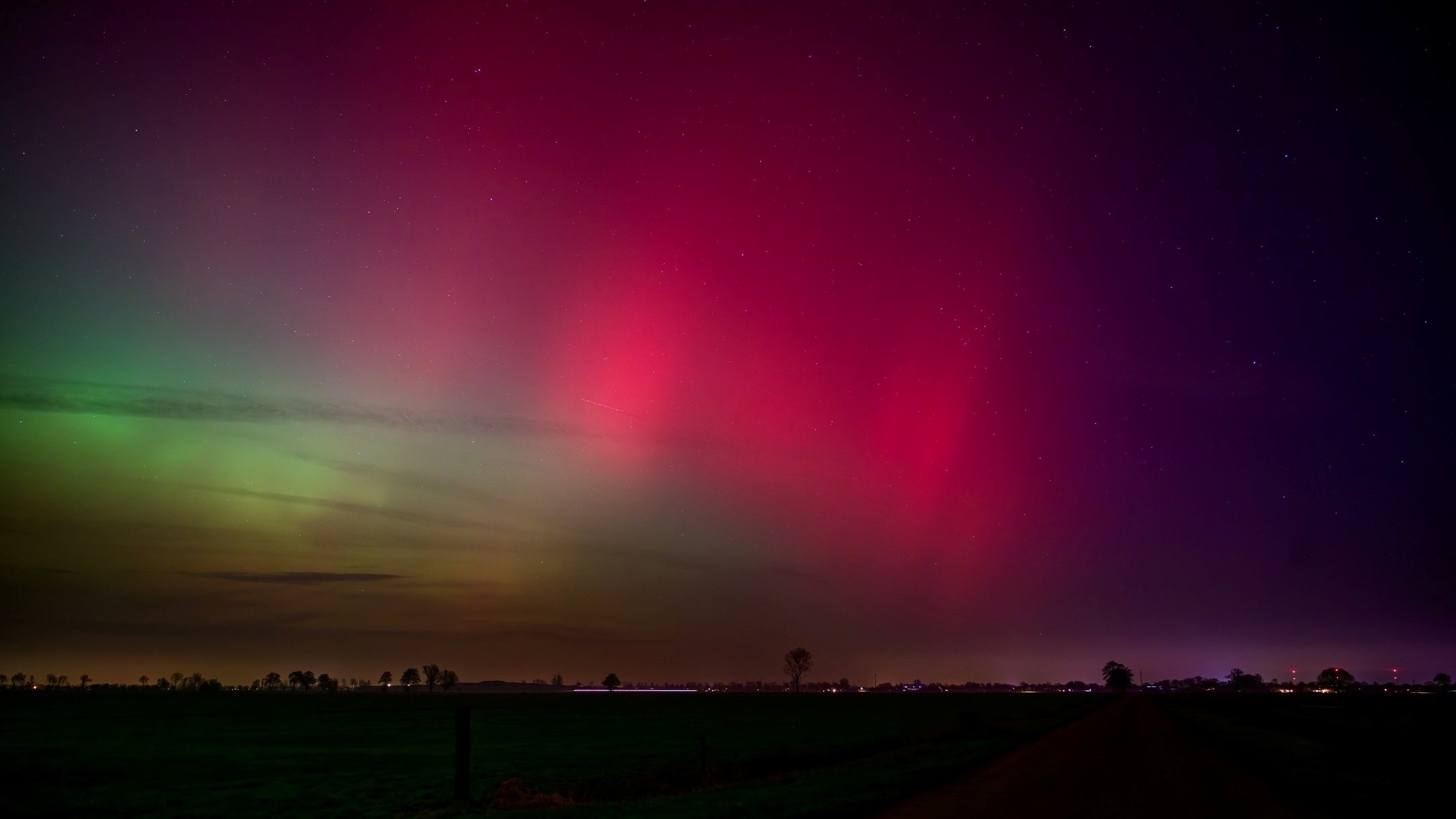 deep magenta aurora in the sky with faint green auroras below.