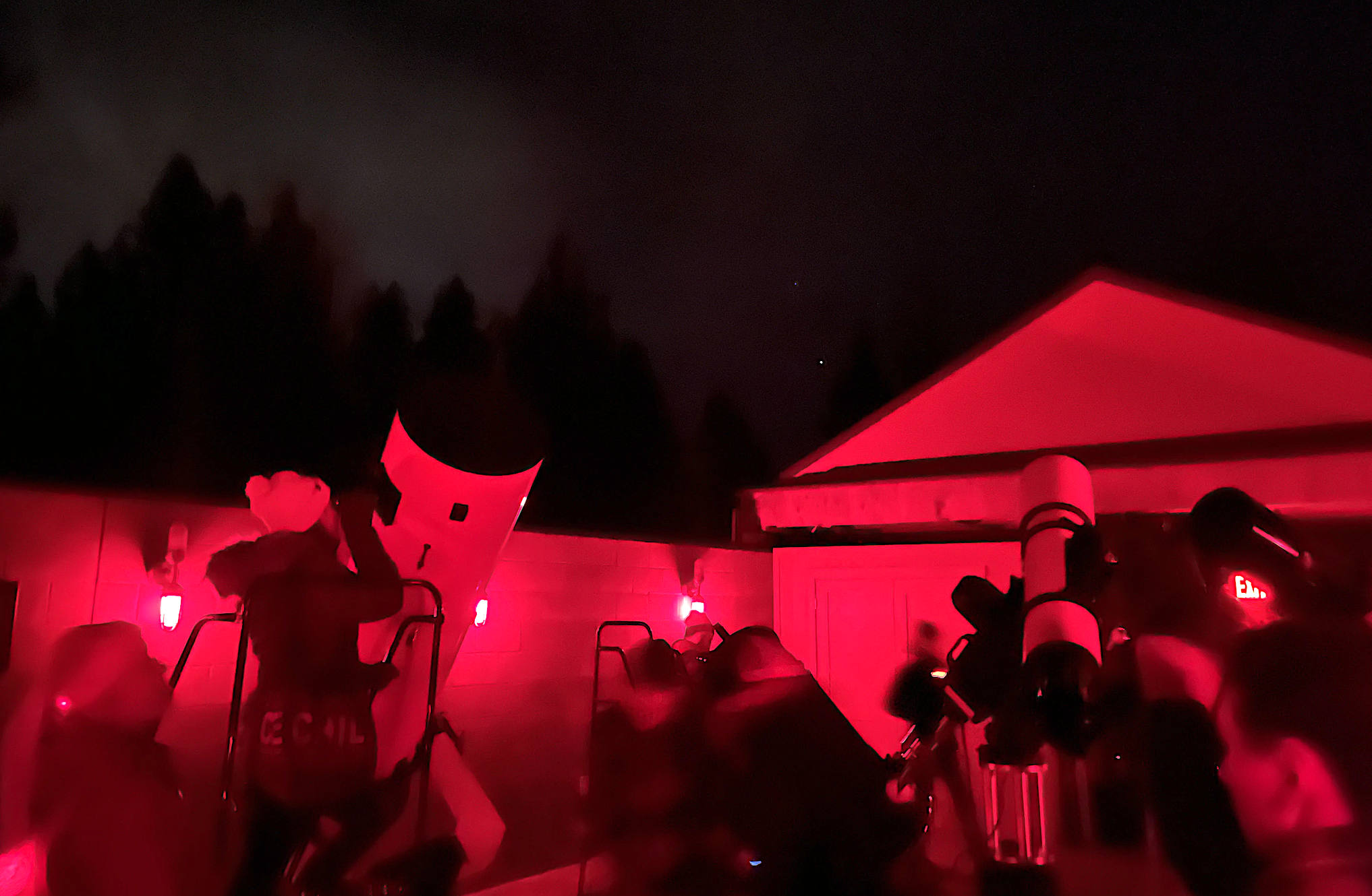 A red-lit observatory with telescopes