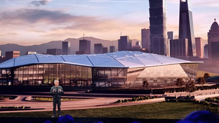 A presenter on stage in front of a futuristic building backdrop with a city skyline.