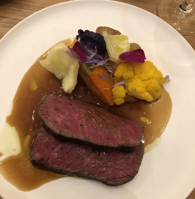 A plate of duck and vegetables.