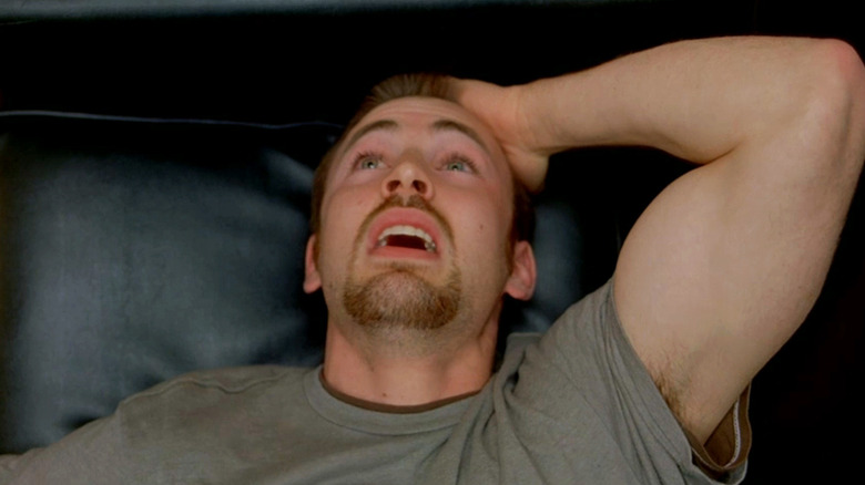 Chris Evans' Syd holds his hand to his head as he lays down in London