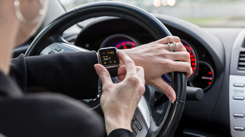 A person using an Apple Watch inside a car.