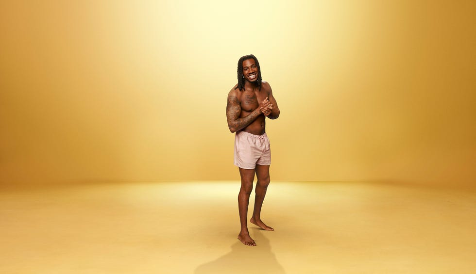 Love Island All Stars Shaq a person standing in a studio with a golden background