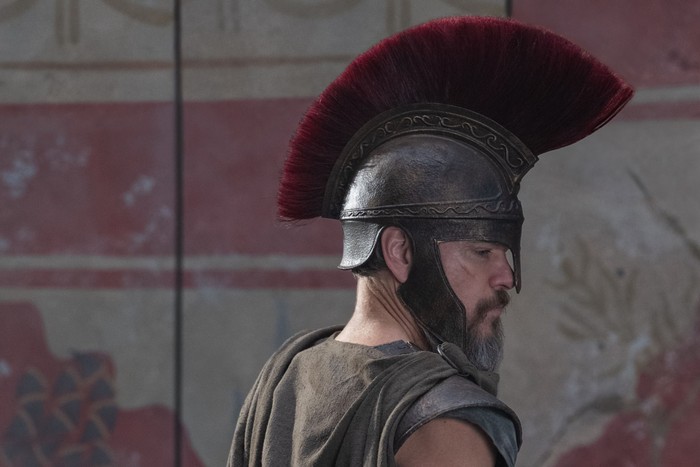 Matt Damon in Roman attire with a hat and shield.