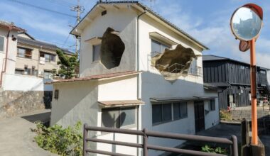 An art installation comprising a small house with holes in it that open to what looks like a cave on the inside