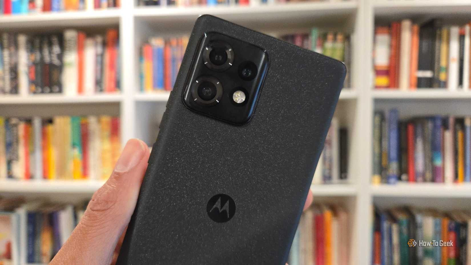 Moto Edge Plus 2023 in front of a bookshelf.