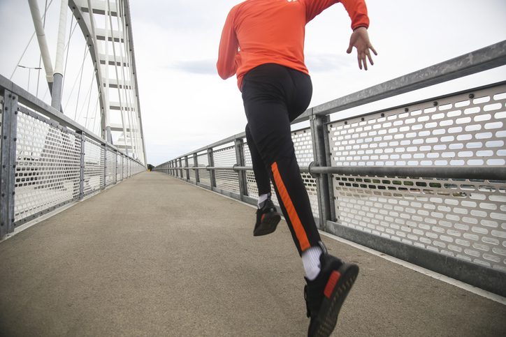 person sprinting on bridge