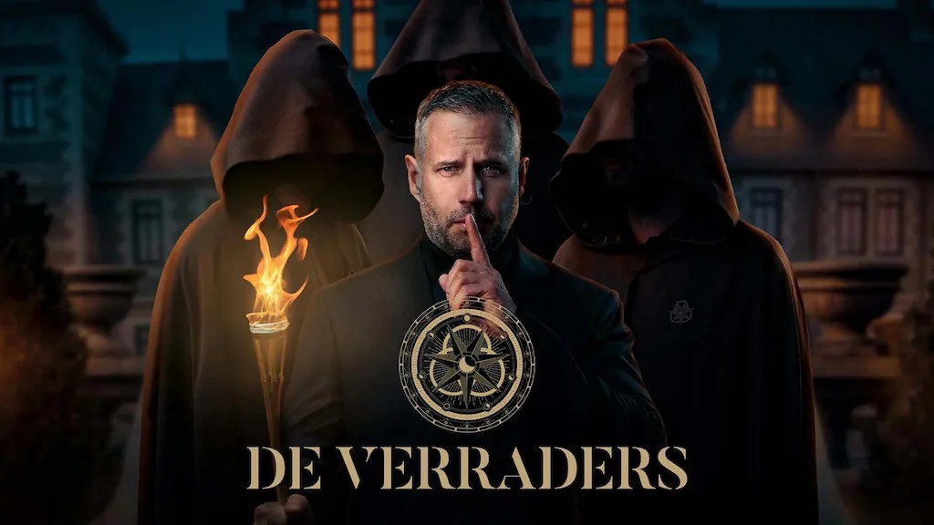 A man in a suit holds a finger to his lips in a "hush" gesture, standing in front of three hooded figures and a large estate under the title "DE VERRADERS."